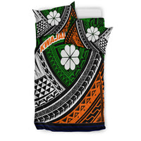 Green, orange, black and white tribal bedding set with white flower shapes and blue trim.