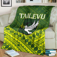 Green Tailevu rugby blanket with white dove logo and bright yellow tapa stripe pattern