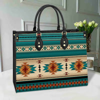 Native pattern leather bag in teal, black handles, gold studs, multicolor stripes