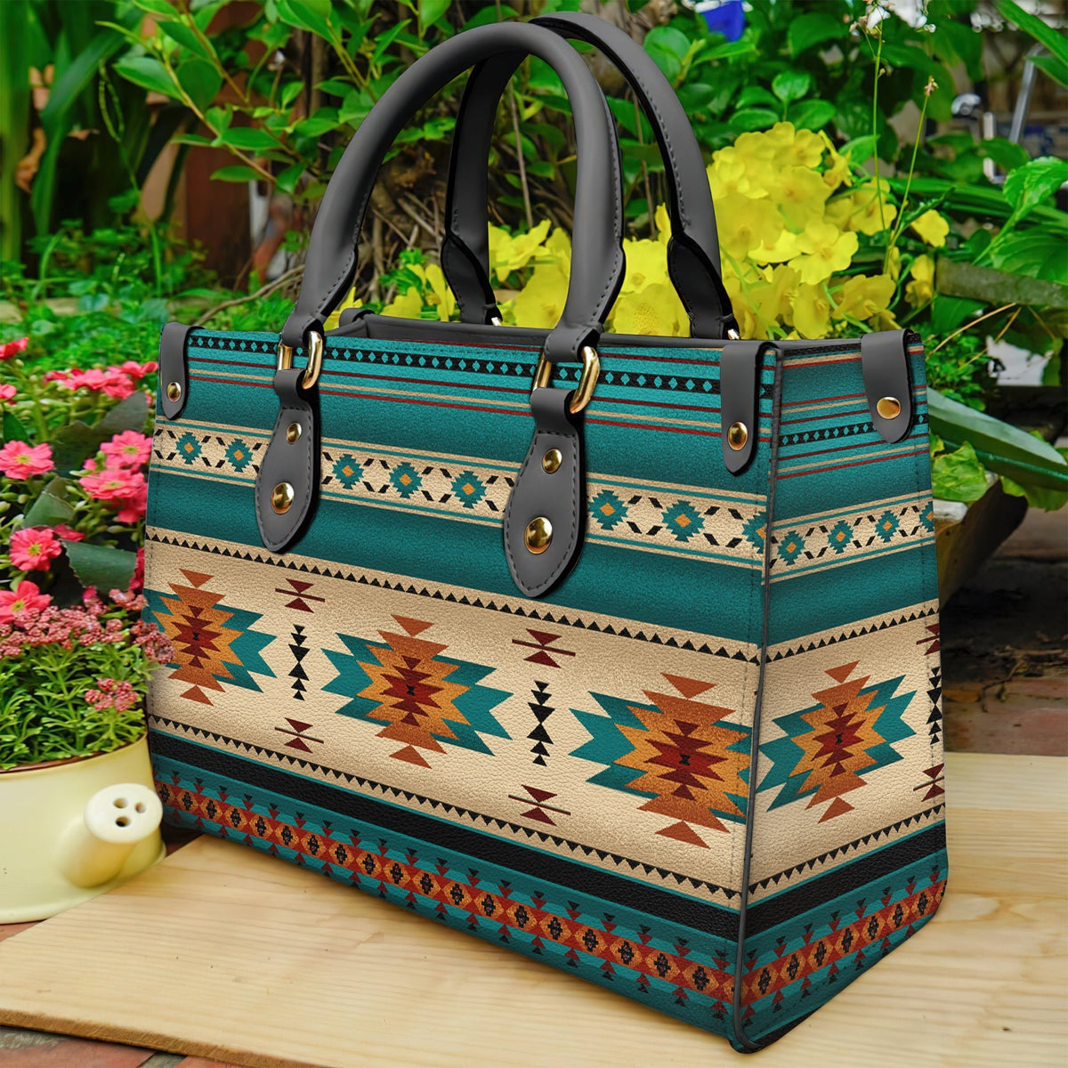 Teal Native pattern leather bag, side view, black strap handles with brass rings