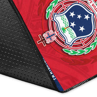 Close-up corner of blue-and-red FAST area rug with stitched black border and emblem