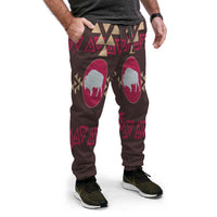 Brown jogger pants with bison silhouette in pink ovals and tribal triangle print, front
