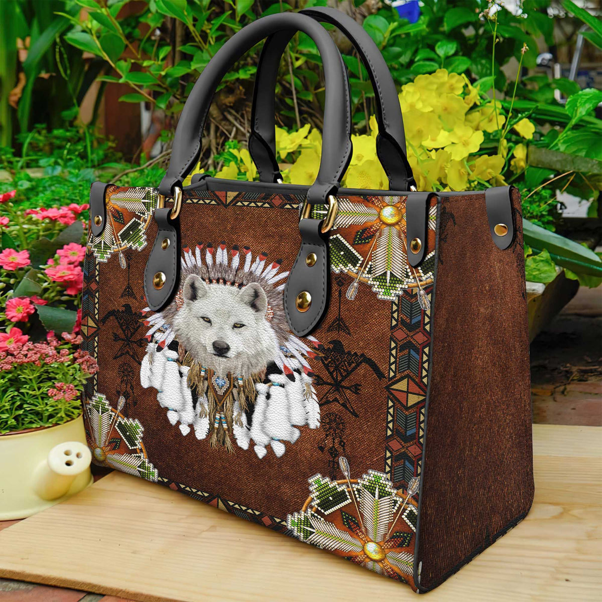 Brown leather tote bag with white wolf head and feather headdress, black handles, studded straps