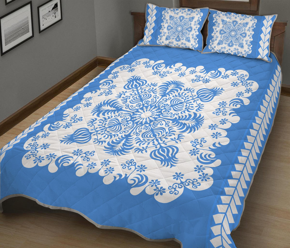Blue quilt with white floral swirl pattern and geometric border; matching pillow shams