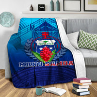 Blue Manu Samoa blanket with white edge, shield crest, and bold “MANU SAMOA” text