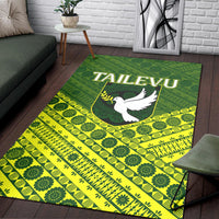Green and yellow Tailevu area rug with white dove logo and geometric tapa-style motifs