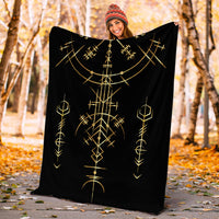 Black art blanket held outdoors, printed with gold geometric rune motifs