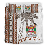 White bedding set featuring brown tapa borders, coconut leaves, and two figure pillows