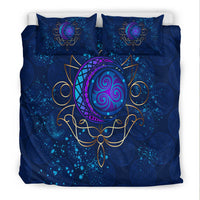 Blue duvet set, close view of central purple moon emblem with gold ornamental lines