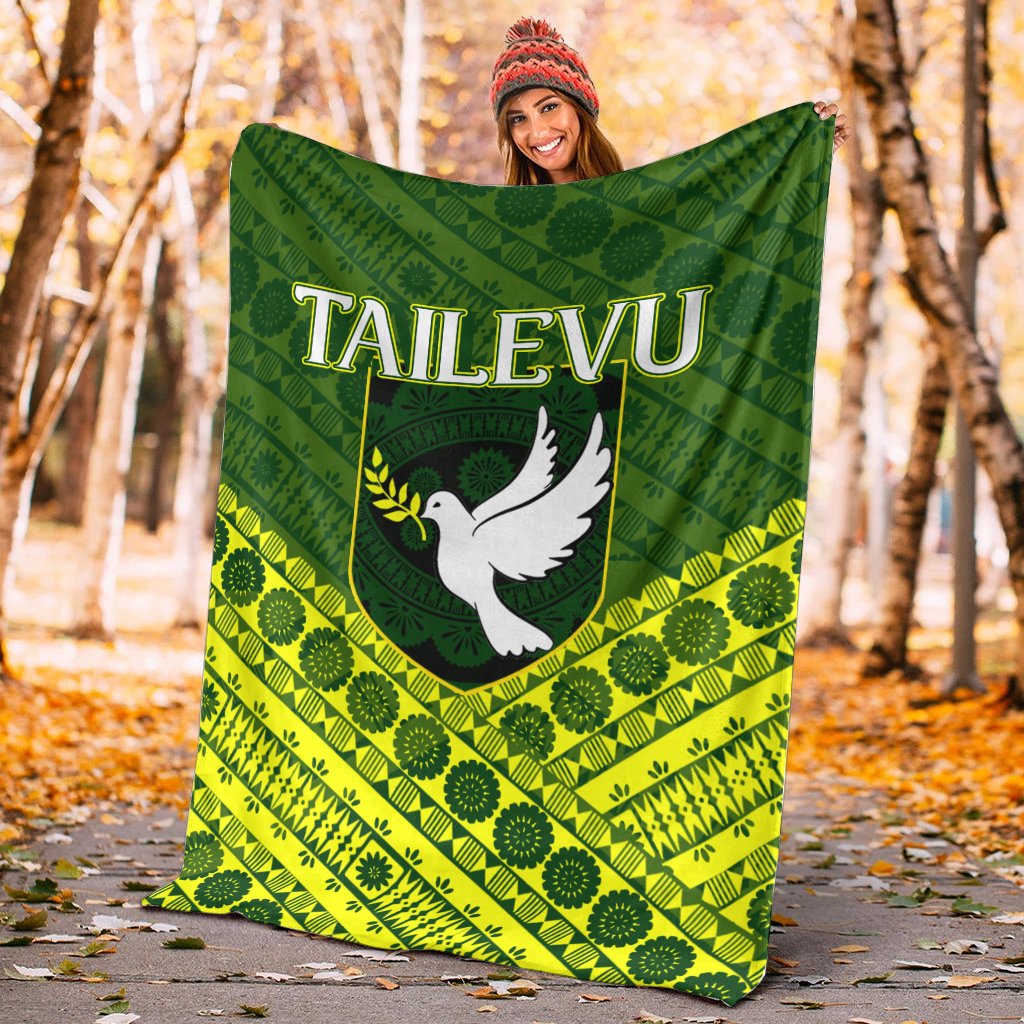 Green and yellow tapa-pattern blanket with white dove 'TAILEVU' logo, large throw size