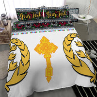 Eritrea Tibeb bedding set: close-up white duvet with golden birds and cross, “Your Text” pillows.