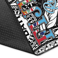 Close-up of black-edged tapa pattern area rug with colorful letter patches and BATI emblem
