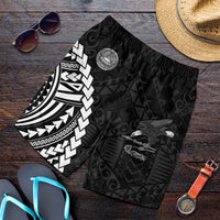 Folded black swim shorts with eagle and Polynesian-style geometric pattern, elastic waist
