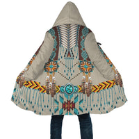 Hem view of hooded cloak with turquoise bead medallion, fringe drops, and geometric trim