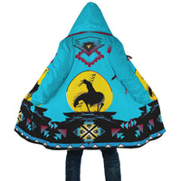 Close-up of turquoise hooded cloak back with horse-on-circle print and geometric band