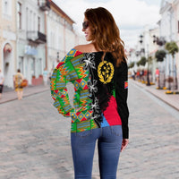 Off-shoulder sweater side view, Eritrea crest and geometric stripe panels on black base