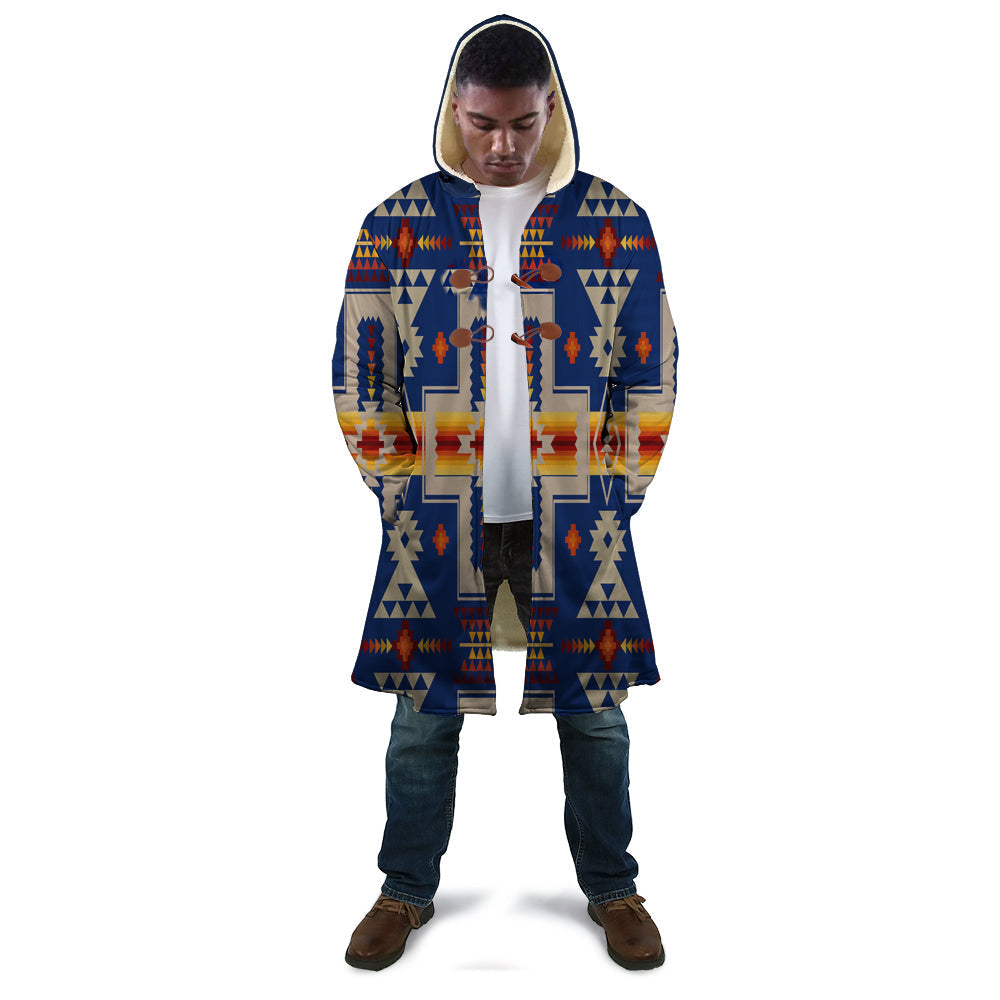 Long navy hooded cloak with multicolor geometric panel design, standing front