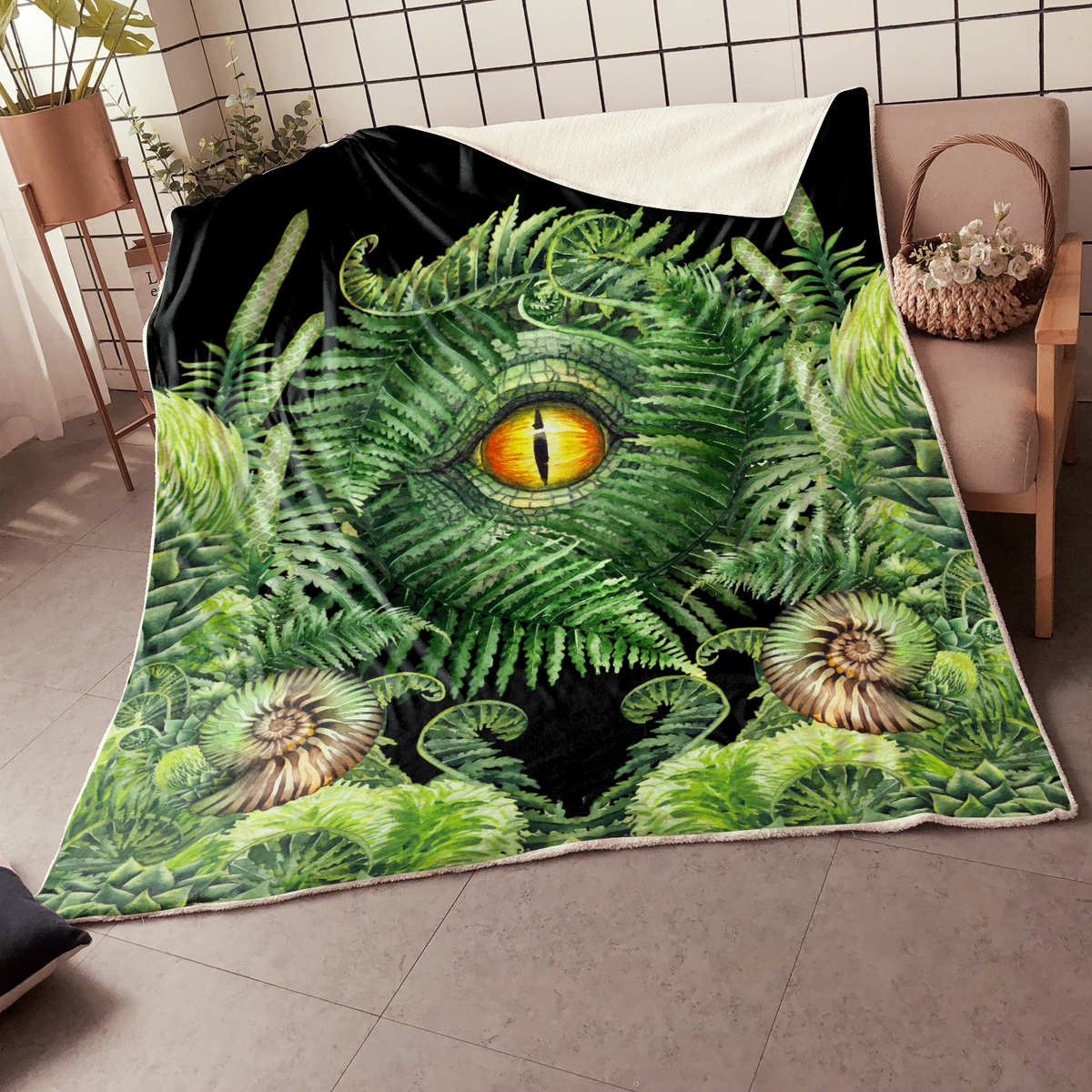 Green fern dinosaur eye blanket with white edge trim, laid on the floor