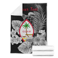 Black Guam turtle blanket set, folded with matching white reverse, floral background