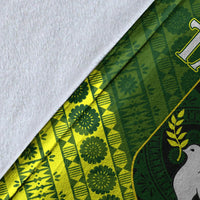Close-up of green tapa pattern fabric with yellow geometric details and dove edge