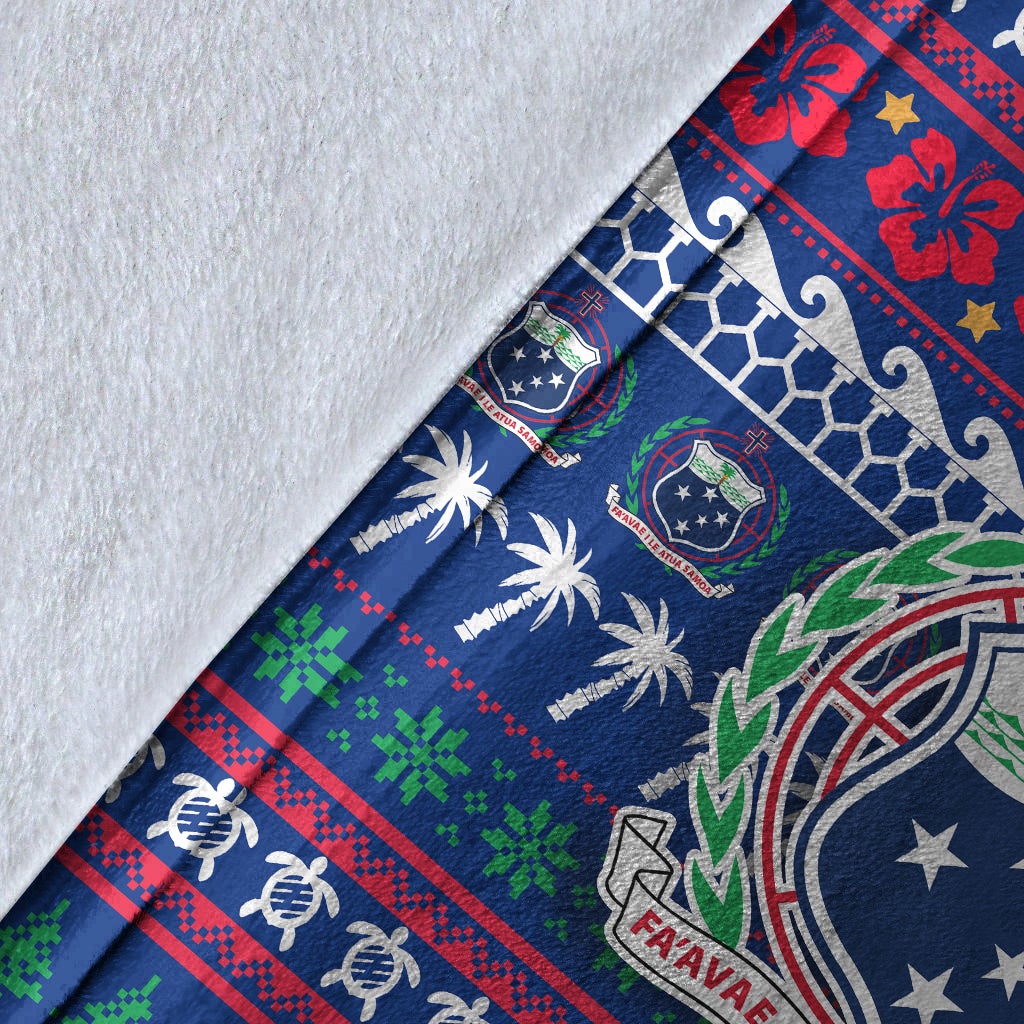 Close-up blue Samoa holiday blanket fabric with crest, palms, and white backing edge