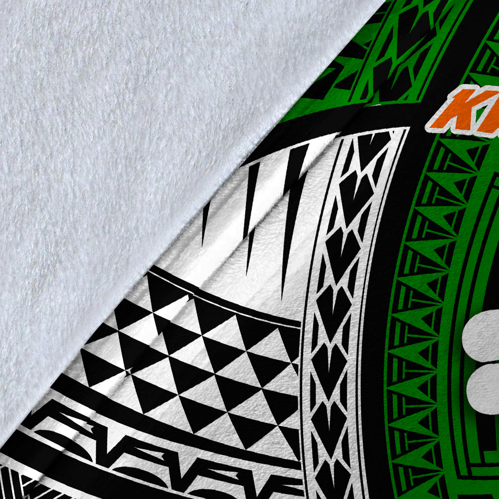 Close-up of tribal blanket fabric: white base with black-and-green pattern and orange details