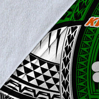 Close-up of tribal blanket fabric: white base with black-and-green pattern and orange details
