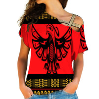 Red cross-shoulder shirt, black phoenix graphic with patterned yellow trim
