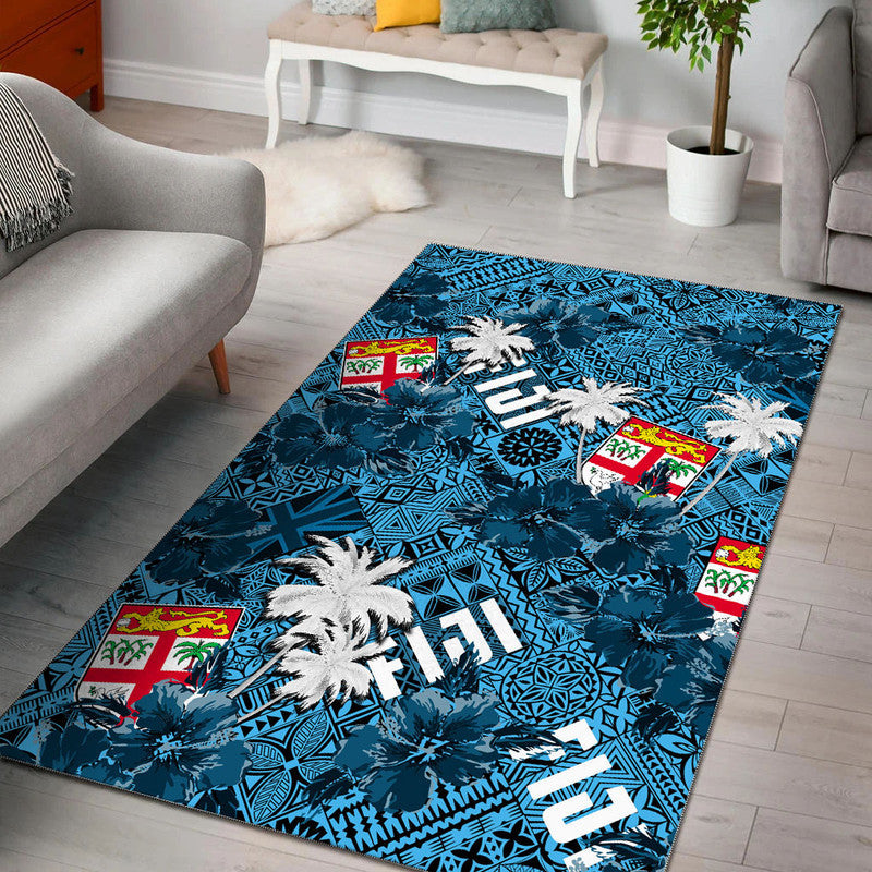 Teal-blue tropical rug with palm trees, hibiscus-like blooms, and geometric patterns