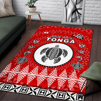Red Tonga rug with circular white emblem, black accents, and leaf-and-ray border