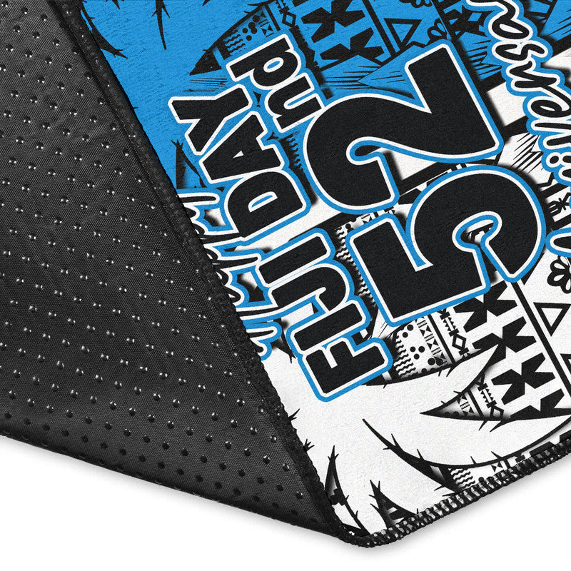 Rug corner detail with black textured backing and blue/white "Happy Fiji Day 52" print