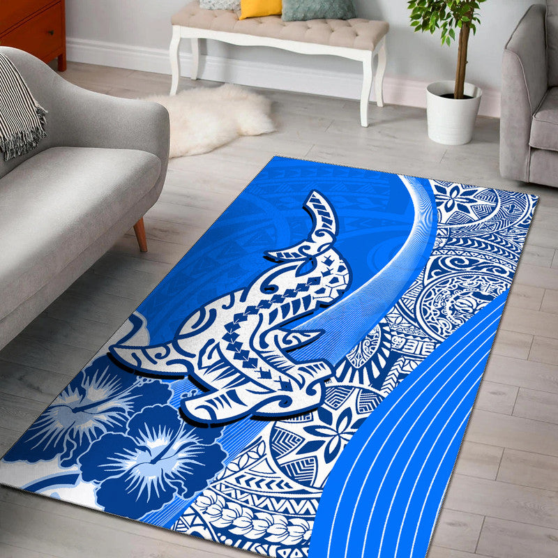 Blue Polynesian style area rug with shark and floral patterns, white motifs, rectangle
