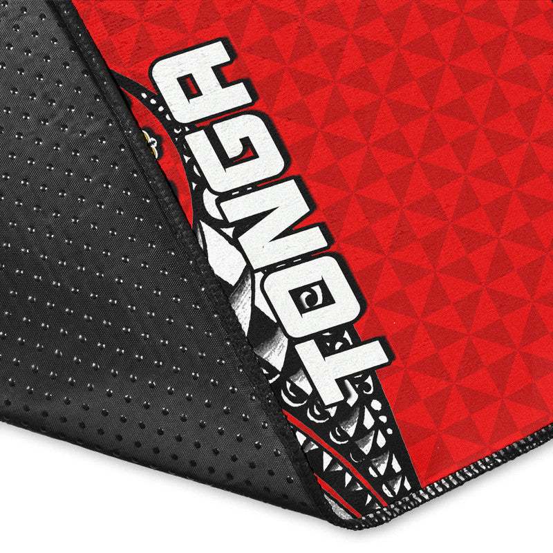 Corner close-up of red Tonga rug with black dotted edge and black/white tribal graphics
