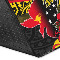 Close-up of black rug edge with stitched border and Papua New Guinea print in red and yellow
