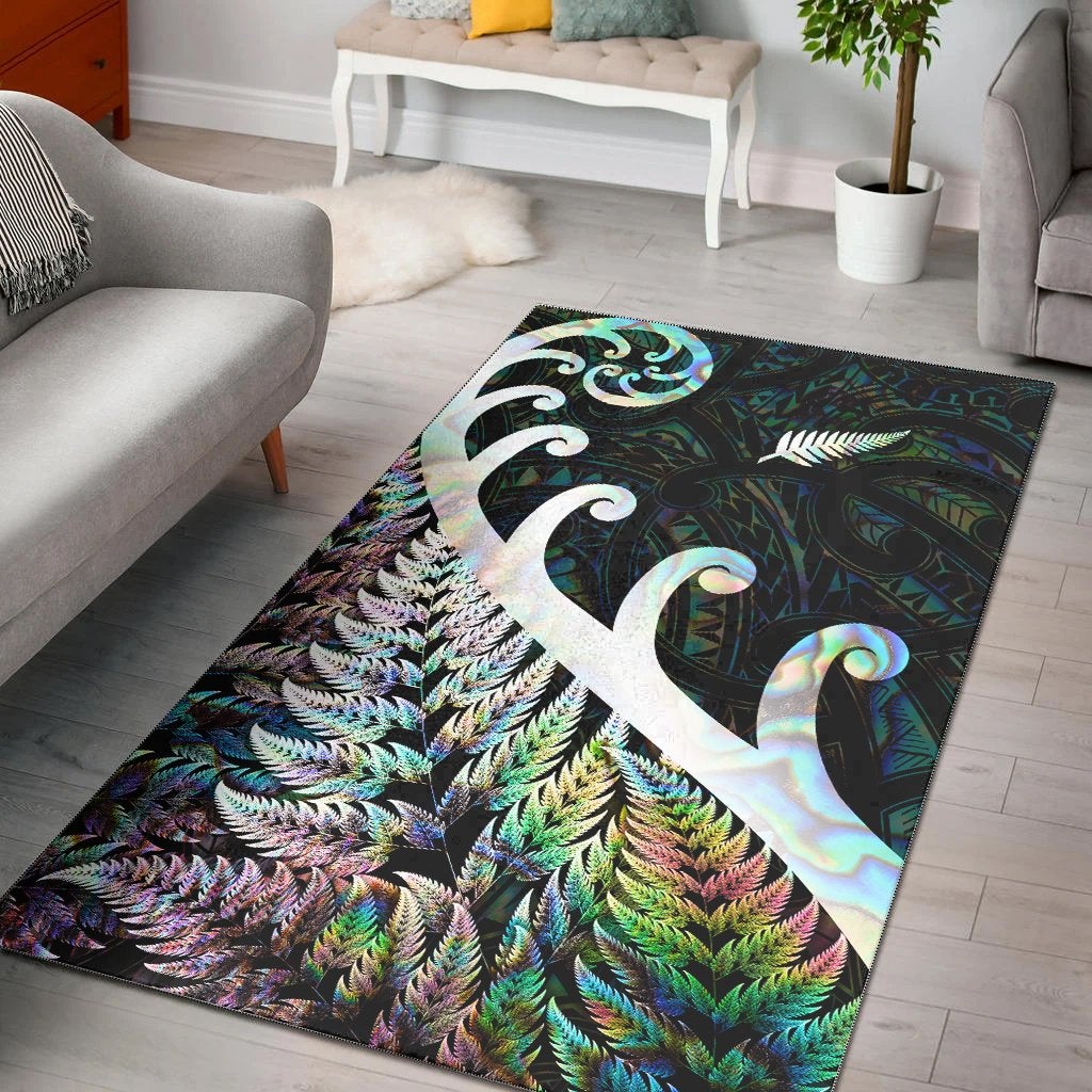 Green area rug with white fern & koru motifs, iridescent shell-like sheen