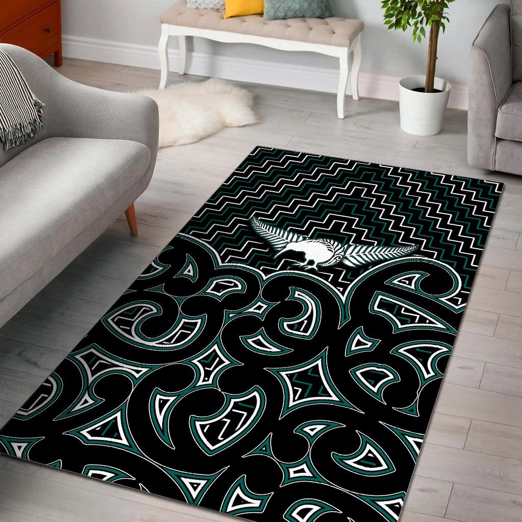 Green-and-black Maori-style graphic area rug with tribal figures and zigzag border