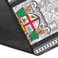 Close-up of black rug edge with dotted texture, black lattice border, and crest graphic