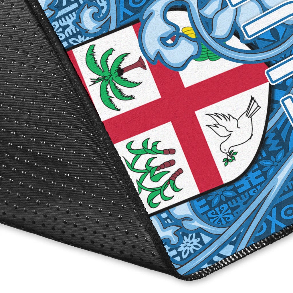 Close-up of blue FIJI rug edges with black backing, tapa border, and Fiji flag cross.