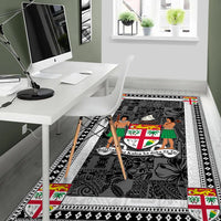 Fiji area rug by desk, dark charcoal design with white border and colorful accents