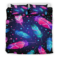 Feather print bedding set with pink, teal, and blue dots; two pillowcases on comforter