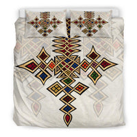 Bedding set front view: multicolor diamond and cross designs on off-white background