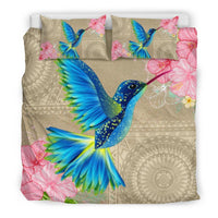Beige bedding set featuring large blue hummingbird, pink hibiscus blooms, and geometric accents