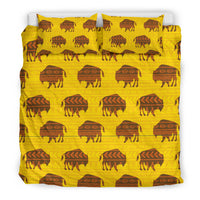 Yellow bedding set with dark bison silhouettes and geometric rows across duvet