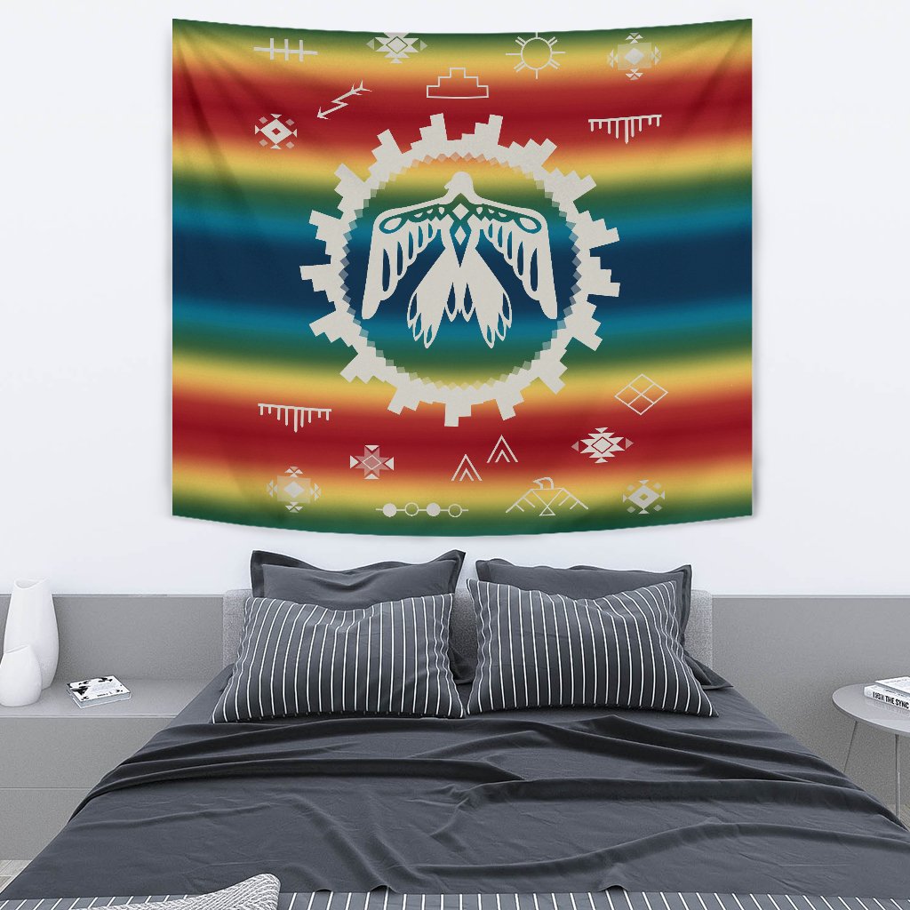 Rainbow striped tapestry featuring teal/green thunderbird emblem with white feather wings