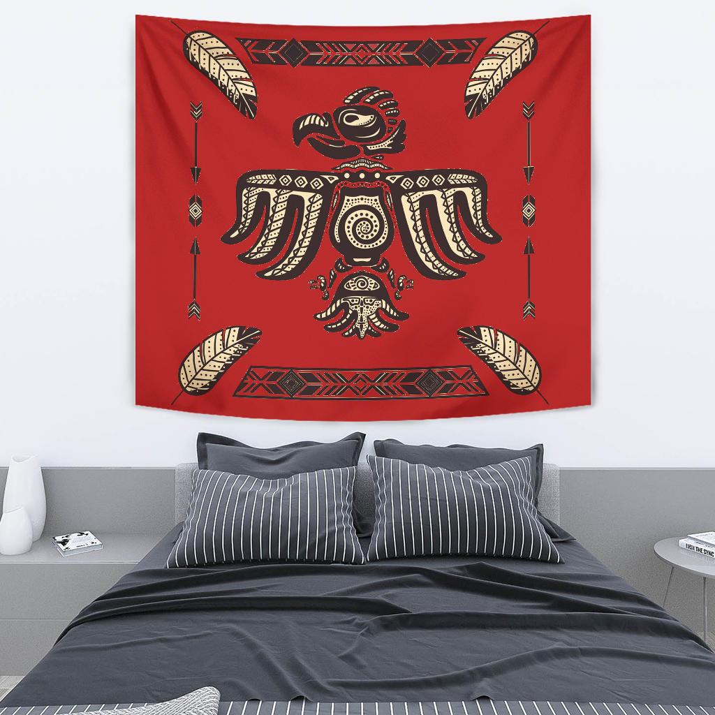 Red tapestry showing native bird with feather wings, central tribal figure and arrows