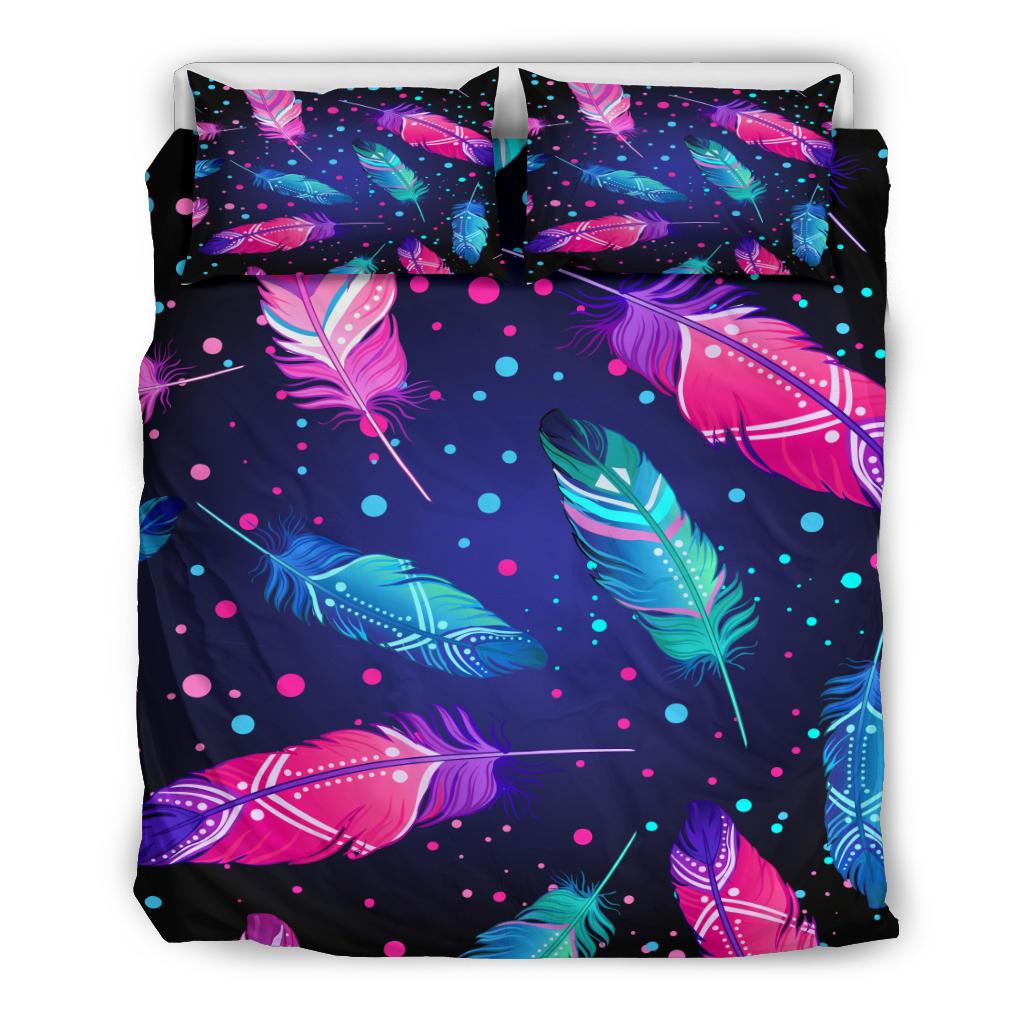 Flat lay of feather-and-dot bedding set: comforter top with two matching pillowcases