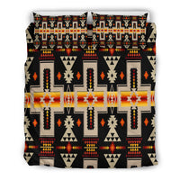 Front view: black duvet cover with bold multicolor geometric Native-inspired motifs and 2 pillows