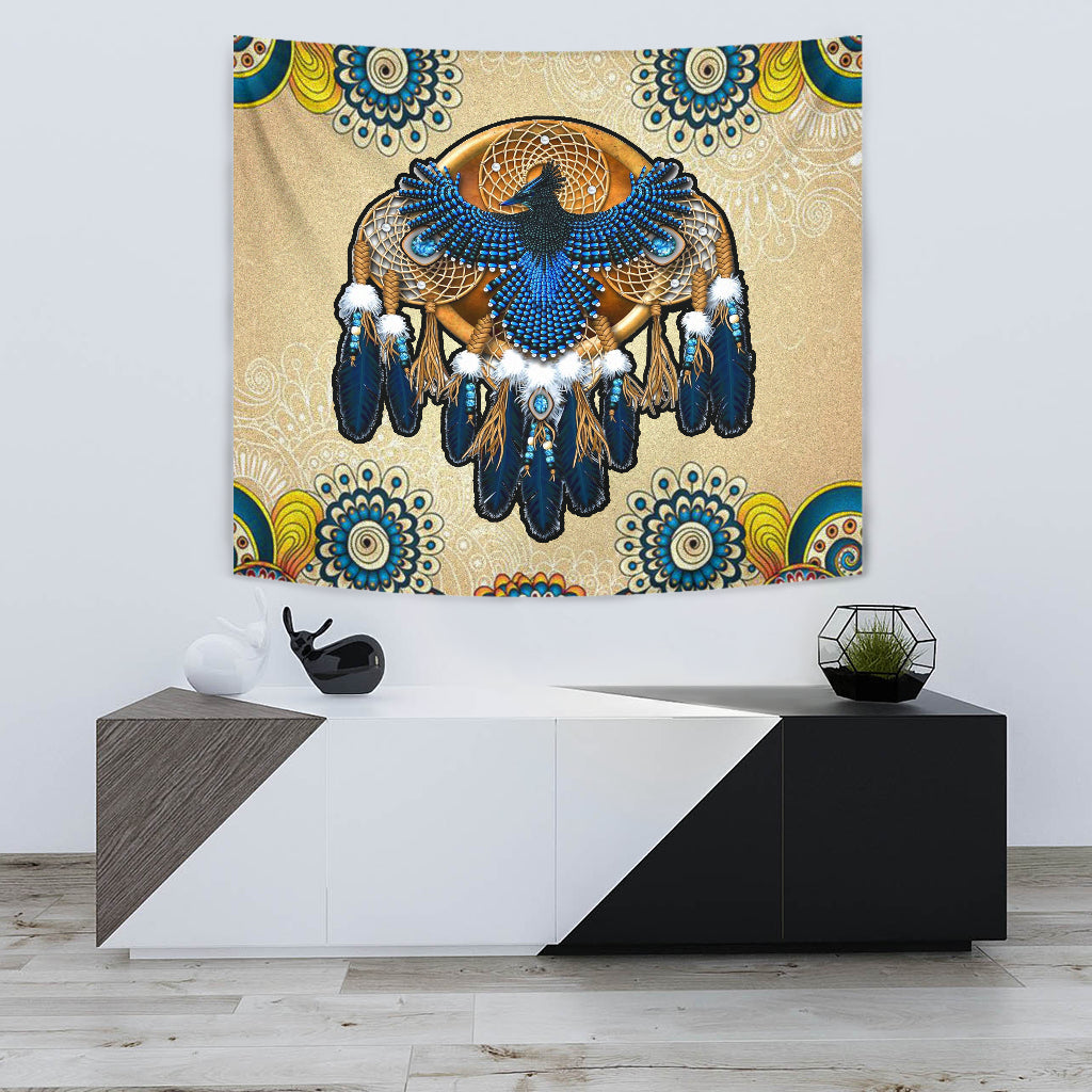 Beige tapestry featuring a blue beaded dreamcatcher with fringed feathers and white pom accents