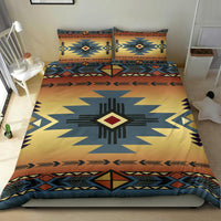 Bedding set on bed: twin pillows and duvet with blue star motif, warm yellow-orange base