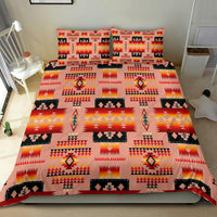 Tan tribal bedding set on bed with repeating geometric patterns, medallions, and flame icons